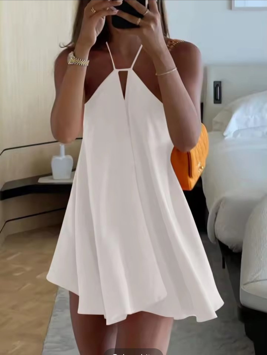 Person wearing a white dress in a bedroom setting