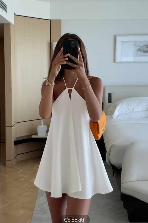 Person wearing a white dress in a bedroom setting